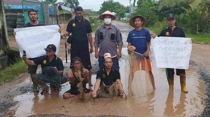 Bentuk aksi protes warga soal Jalan di Bunyu yang rusak parah, dengan cara berdiri di atas jalan rusak tergenang air.
